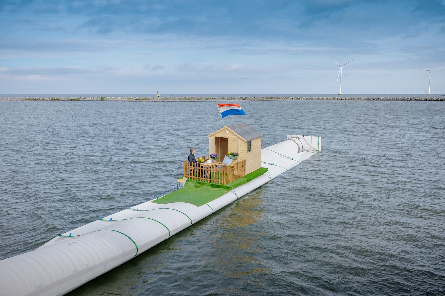 A wind turbine blade turned into a boat house floating on water.